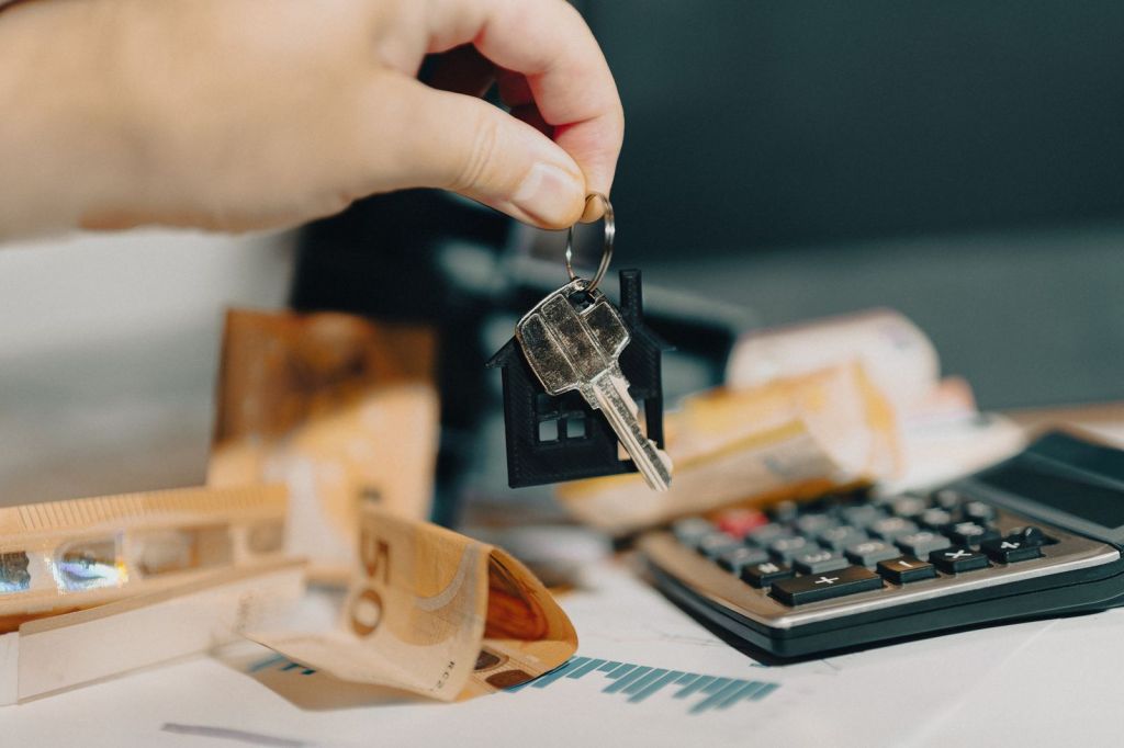 Clés d'un bien immobilier, billets et calculatrice